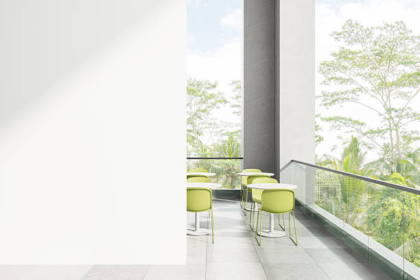 istock Modern balcony cafe interior with blank white wall for poster mockup presentation and green chairs overlooking tropical trees and sky landscape. 3D Rendering 2219300136