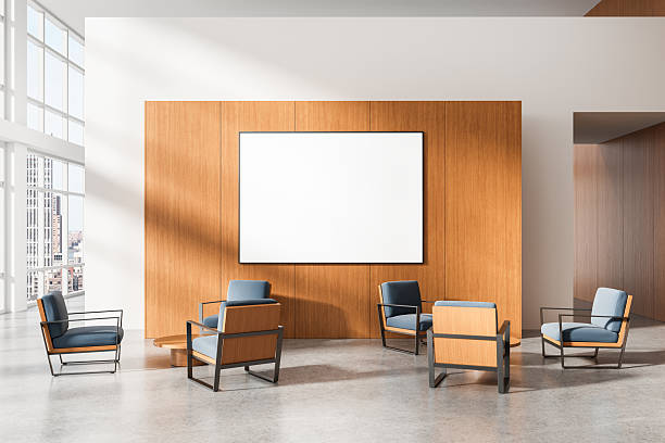 istock Modern interior with empty framed poster mockup on wooden wall and designer chairs in bright office lounge area with city view windows and clean layout. 3D Rendering 2219300410