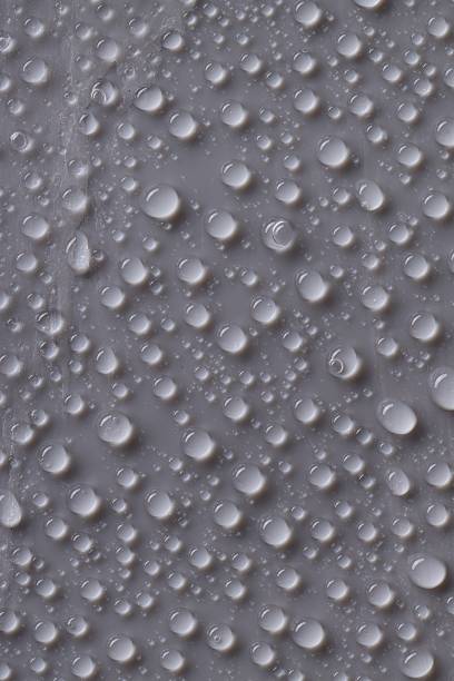 Water drops on gray background, top view