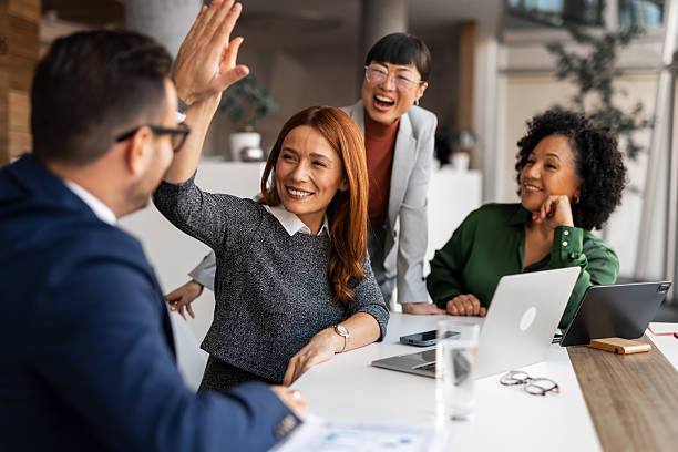 Diverse Team Celebrating Success With a High Five in Modern Office