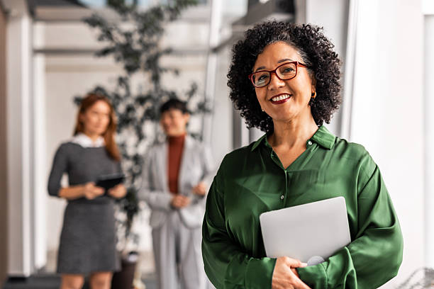 istock Confident Woman in Office with Colleagues in Background 2219301786