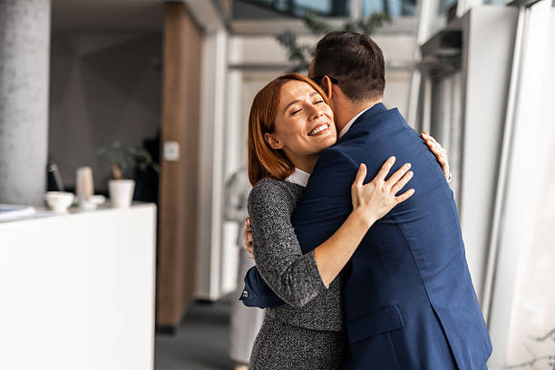 istock Professional Colleagues Sharing a Friendly Embrace in a Modern Office Setting 2219301953