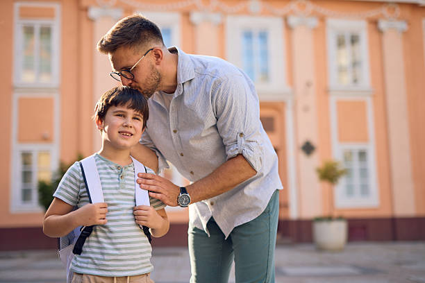 istock Father kissing his son on the forehead before school 2219302643