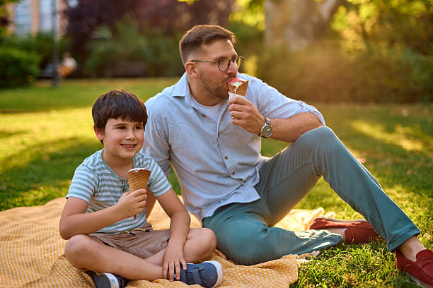 istock Father and son enjoying ice cream cones in the park during sunset 2219302784