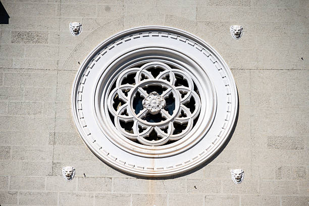 Reggio Calabria - Kalabrien - Italy - 05-25-2025: Circular window with floral tracery on San Paolo alla Rotonda church facade in Reggio Calabria, Italy, featuring stone lion heads.