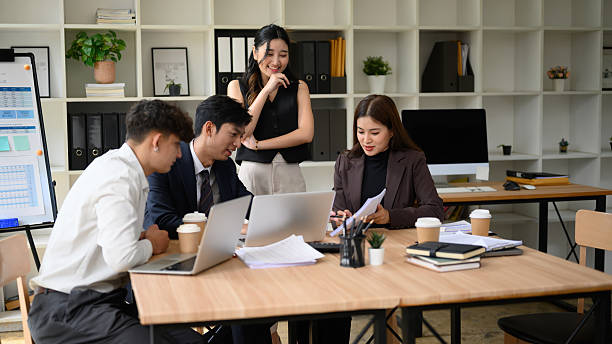 istock A diverse business professional team works together, analyzing documents and financial data in a modern office setting, promoting teamwork and strategy development 2219304558
