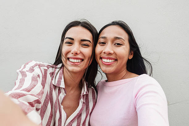 istock Happy hispanic friends having fun doing selfie with mobile phone app - Generation z lifestyle and influencer concept - Focus on faces 2219305735