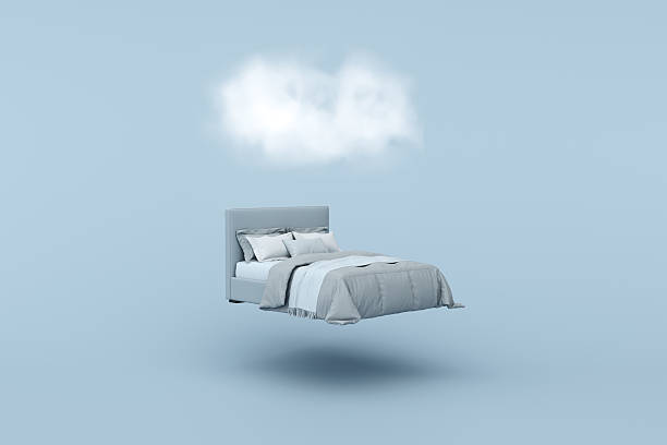 istock Bed floating in a light blue room with a cloud above symbolizing dreaming and good sleep 2219308324
