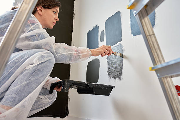 istock Woman Testing Black Paint Samples on Wall During Apartment Renovation 2219308476