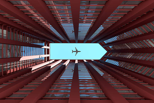 Low angle view capturing an airplane soaring above a modern red building, framed by the sleek lines of the courtyard and sky