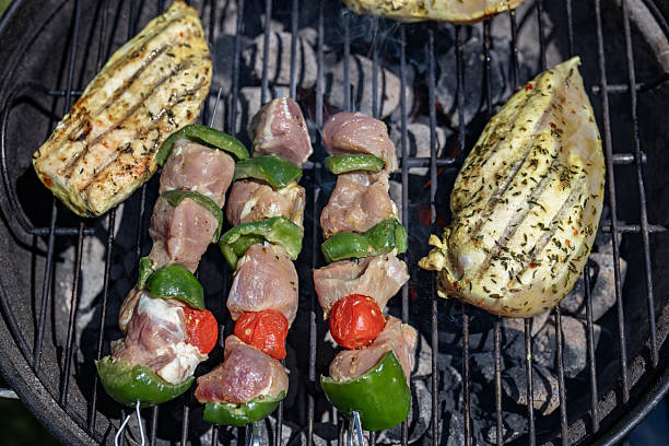Meat cooking on a wood-fired barbecue in a garden, a daily pleasure for the summer season which is just beginning