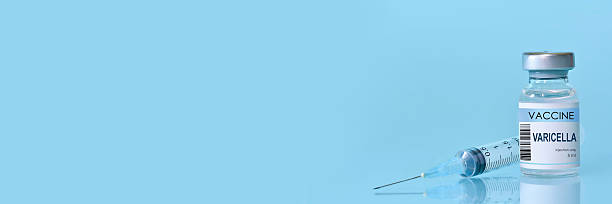 istock Varicella vaccine bottle and syringe placed on a clean blue background, representing healthcare, medical science, immunization awareness, and disease prevention. Banner with copy space 2219309934