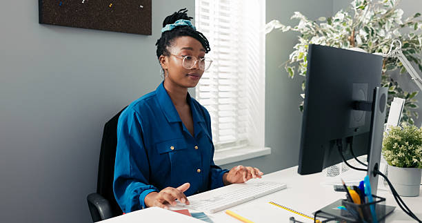 istock A skilled company secretary sits in front of a computer, typing emails, organizing reports, and preparing important documents and meeting minutes for the manager in a busy office. 2219310718