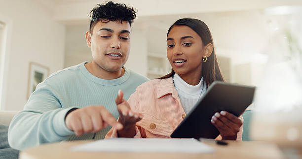 istock Tablet, planning and documents with couple at home for lease agreement, online application and support. Mortgage review, research and digital policy with man and woman in living room for paperwork 2219314222