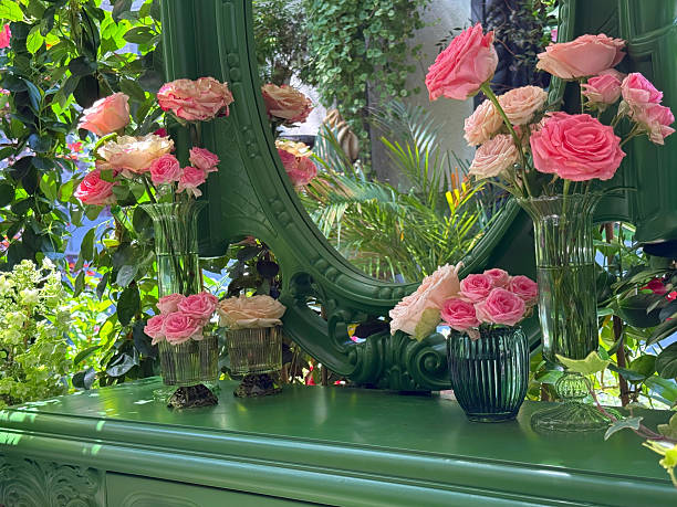 Bouquets of pretty pink roses on a dressing table with a mirror.