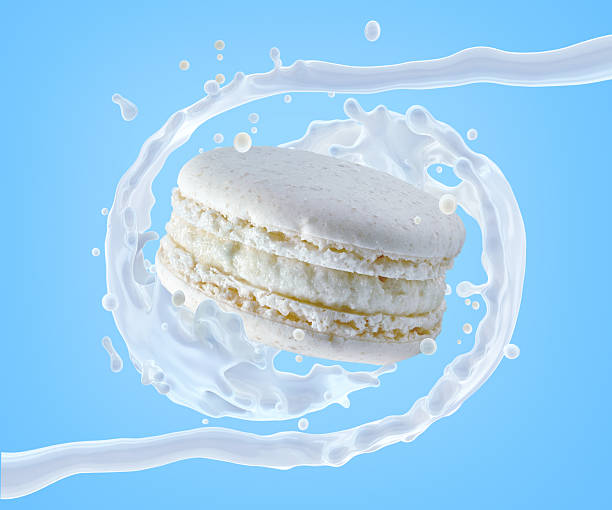 istock White macaron surrounded by a dynamic splash of milk on a blue 2219316603