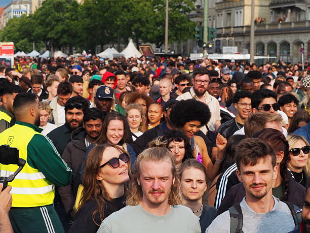Berlin, Germany – June 8, 2025: Large crowds cheer and celebrate along the streets during the Carnival of Cultures parade in Berlin. Spectators of all ages line the sidewalks, waving, clapping, and joining in the festivities as multicultural groups perform during the parade. The joyful atmosphere reflects the inclusive and vibrant spirit of one of Berlin’s most popular public festivals, attracting locals and international visitors alike.