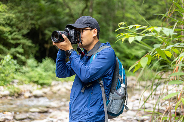 istock Man hiking outdoors, taking photos with camera 2219318124