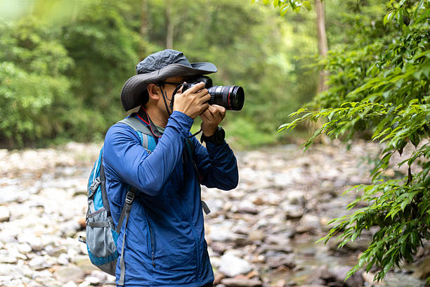 istock Man hiking outdoors, taking photos with camera 2219318125