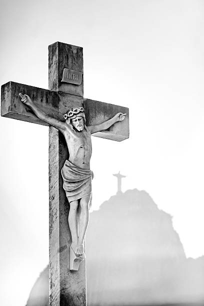 Christ Crucified next to the Corcovado Mountain, Rio de Janeiro, Brazil. Black and white image of a statue of Christ Crucified in the foreground. São João Batista Cemetery, Rio de Janeiro, Brazil. what mountain was jesus crucified on stock pictures, royalty-free photos & images