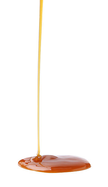 istock Tasty caramel sauce dripping on white background, closeup 2219321414