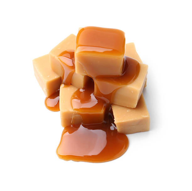 istock Tasty candies with caramel sauce isolated on white 2219321422