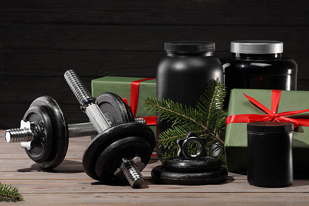 istock Dumbbells, containers with supplement and Christmas decor on wooden table 2219322120