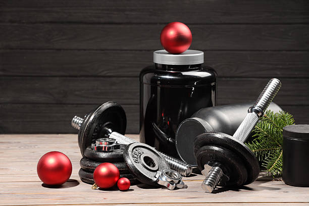 istock Dumbbells, containers with supplement and Christmas decor on wooden table 2219322140