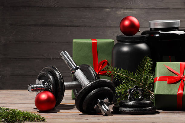 istock Dumbbells, containers with supplement and Christmas decor on wooden table 2219322186
