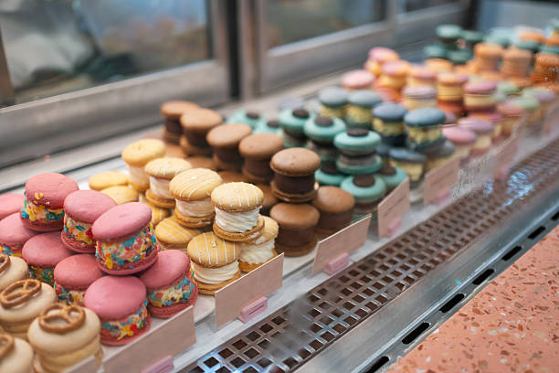 Colorful macarons neatly displayed with vibrant flavors and decorative fillings, ready to be served in a dessert shop.