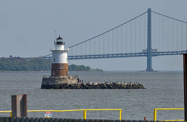 istock small red and white lighthouse with Verrazzano bridge in the background (brooklyn staten island narrows hudson river waterfront bay) light house monument landmark travel 2219328519