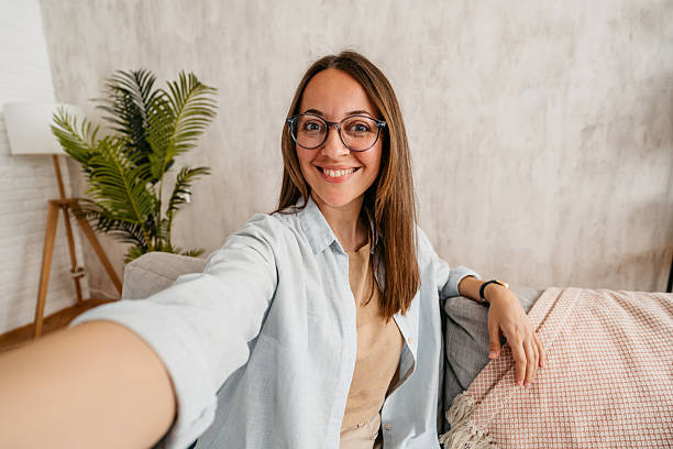 istock Young Woman Taking Selfies While Sitting On The Sofa At Home 2219329316