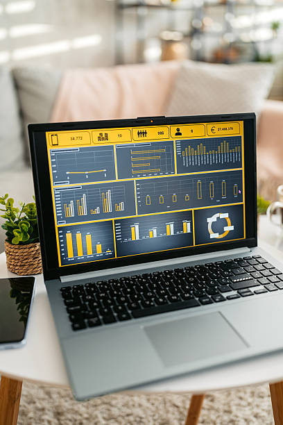 A laptop with different graphs on the coffee table in the living room. Close-up.