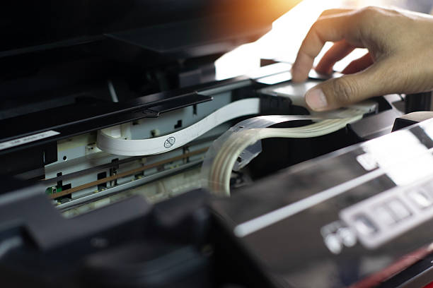 istock Side view of technician inspecting and repairing printer. 2219330031