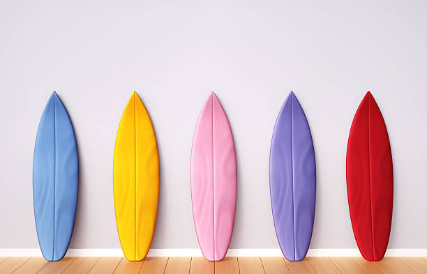 istock Multi-colored surfboards near wall with place for text 2219333466