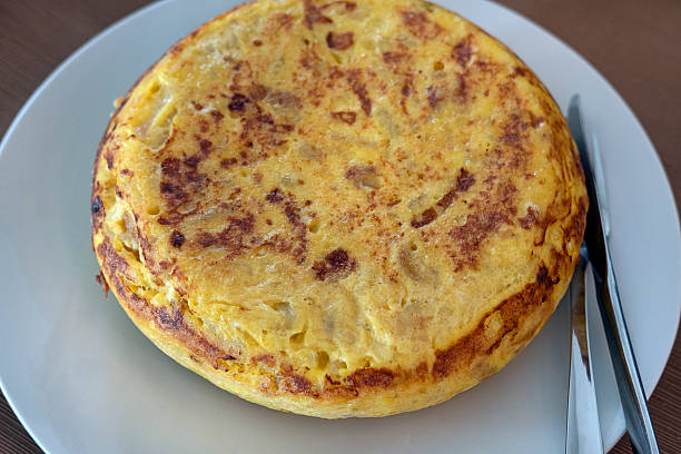 istock Homemade whole tortilla set on a table, golden-brown omelette prepared with eggs, thinly sliced potatoes and sweet onions 2219334210