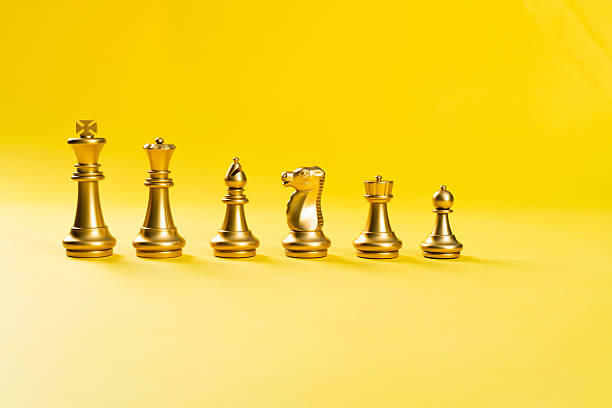 istock A row of chess pieces on yellow background 2219335052
