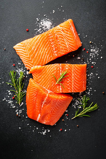 Top view of raw fishes with spices on table. Omega 3 food ingredients with raw mackerel fish, sardines , squid and spices for cooking.
