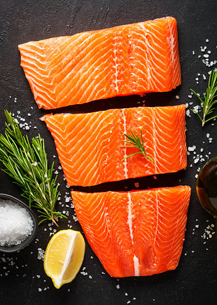 istock Salmon fish with spices and rosemary on black. 2219335409