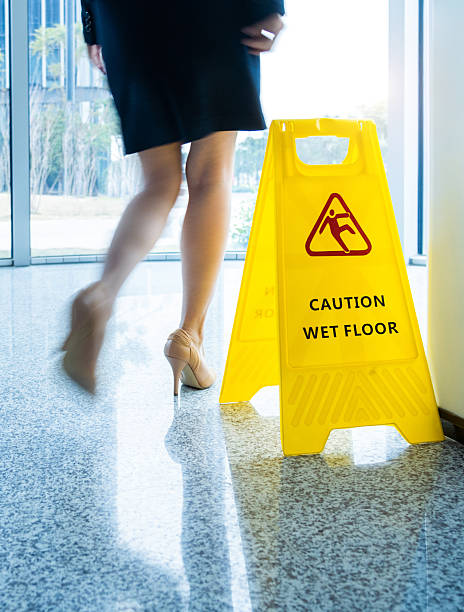 istock Caution wet floor sign with motion blurred legs walking 2219335636