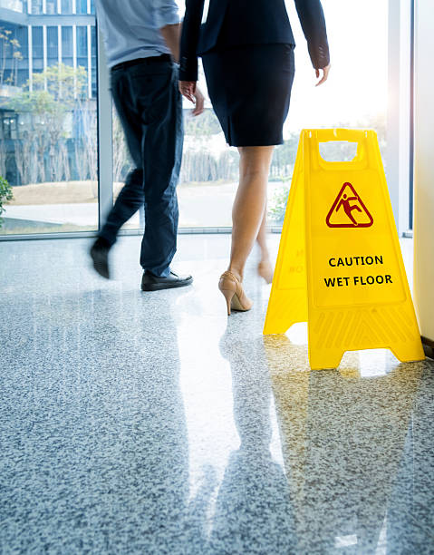 istock Caution wet floor sign with motion blurred legs walking 2219335762