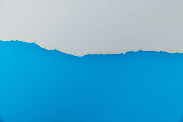 istock Tear white paper to reveal the blue background 2219335844