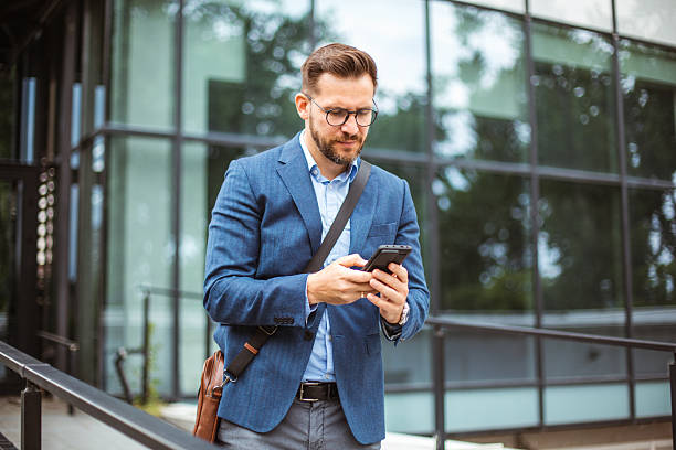 istock Businessman using smartphone outside office building in the city 2219337030