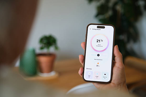 istock Woman using smart home app on mobile phone, controlling living room temperature and devices 2219340315