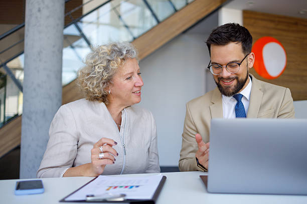 istock Business colleagues collaborating at sleek workspace, reviewing data-driven charts on laptop screen during strategic meeting 2219345338