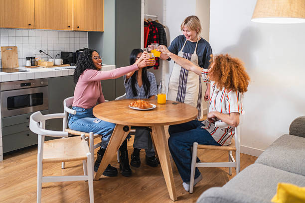 istock Young women toasting orange juice at kitchen table 2219346397
