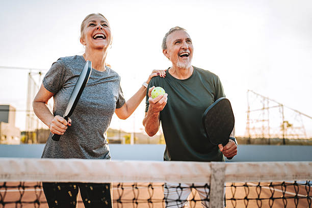 Mature, elderly couple play pickleball together