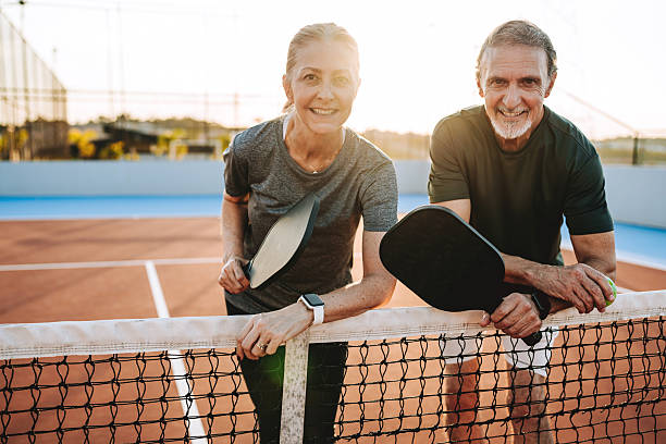 istock Mature, elderly couple play pickleball together 2219346975
