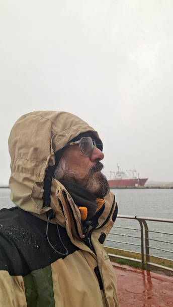 Mature man looking out to sea on a misty day in Ushuaia in the far south of Argentina
