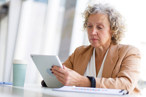 istock Senior businesswoman analyzing data on a digital tablet while working in a modern office environment, showcasing her expertise in finance 2219350325